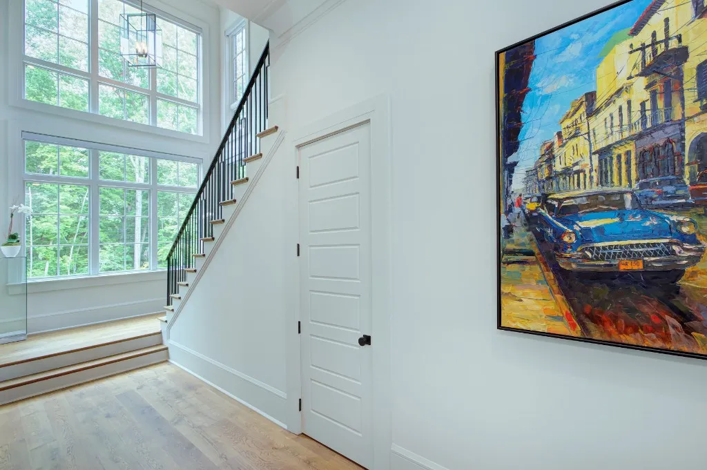 Mtn Lake — stair hall with forest views and gallery art