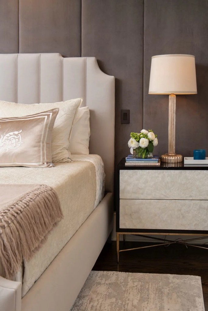 Primary bedroom with upholstered headboard and tailored nightstand